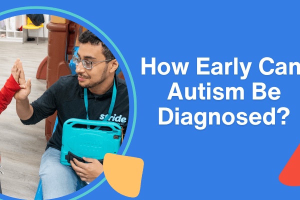 A young child in a red shirt gives a high-five to a therapist wearing a black Stride Autism Centers jacket.